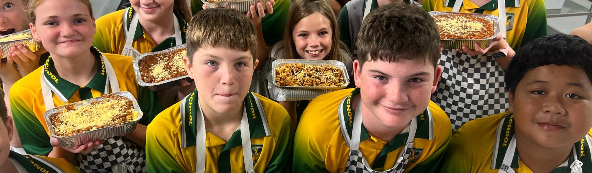 students showing the food they have cooked